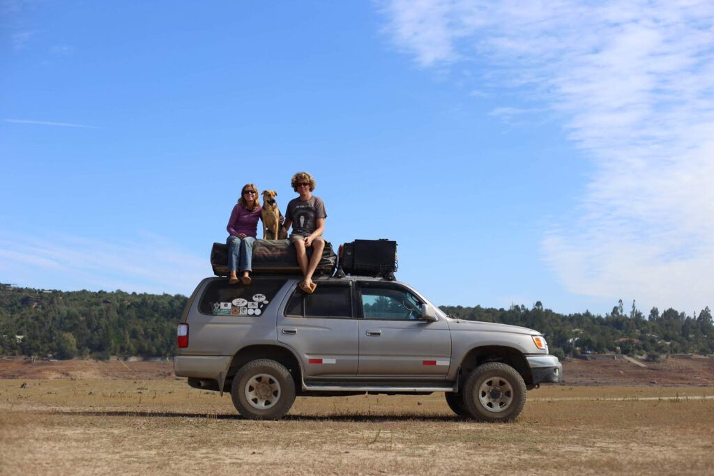 Emma and Benjamin sitting with Kaylee on top of their 4Runner during their road trip through Latin America.